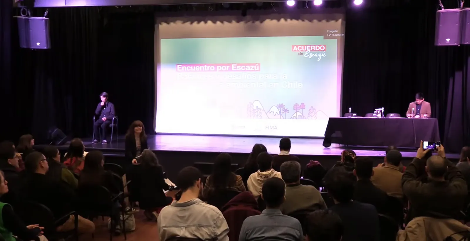 Plano general del auditorio con el público y la pantalla del Encuentro Escazú