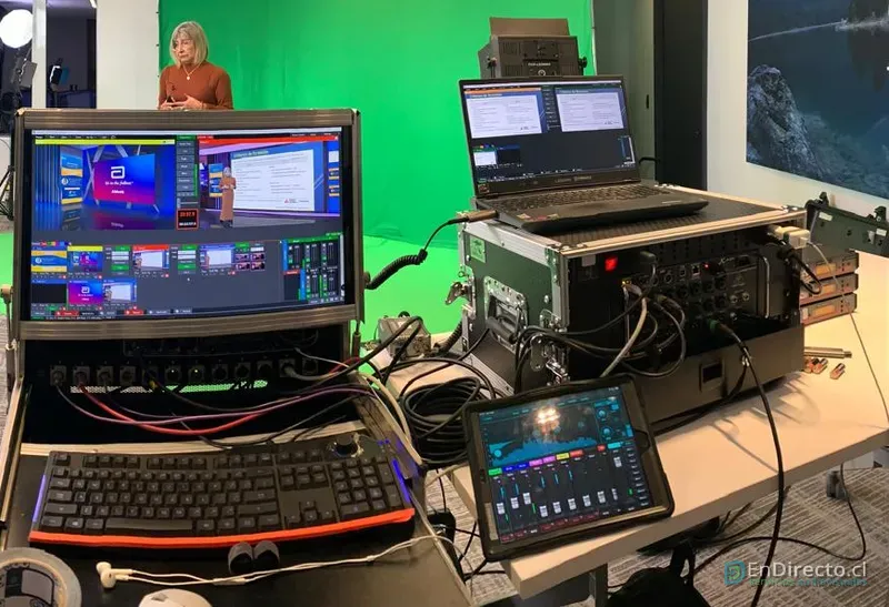 Mesa de producción con la escenografía virtual en pantalla y la mezcla de audio en una tablet